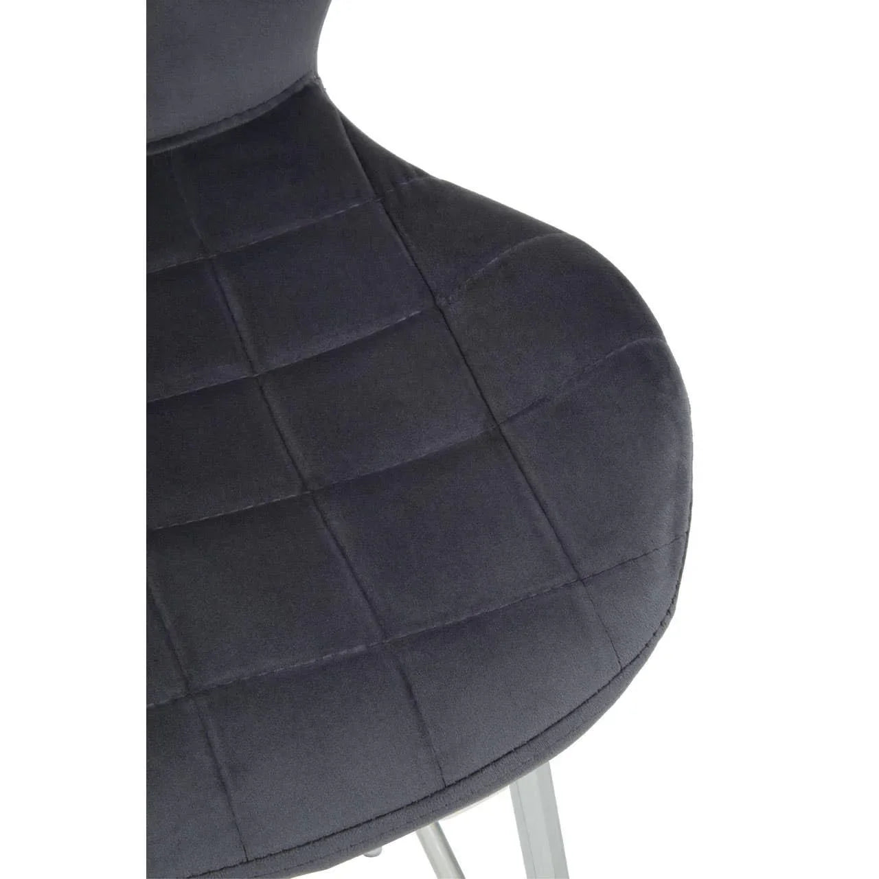 Close-up of dark grey velvet dining chair seat with grid stitching and chrome legs