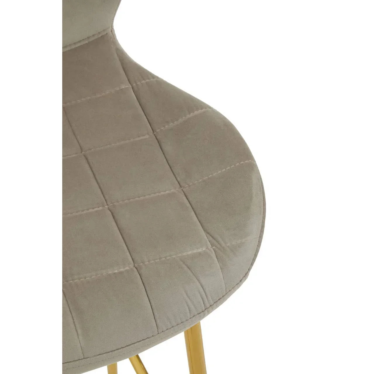 Beige velvet dining chair seat with grid stitching and gold metal legs closeup