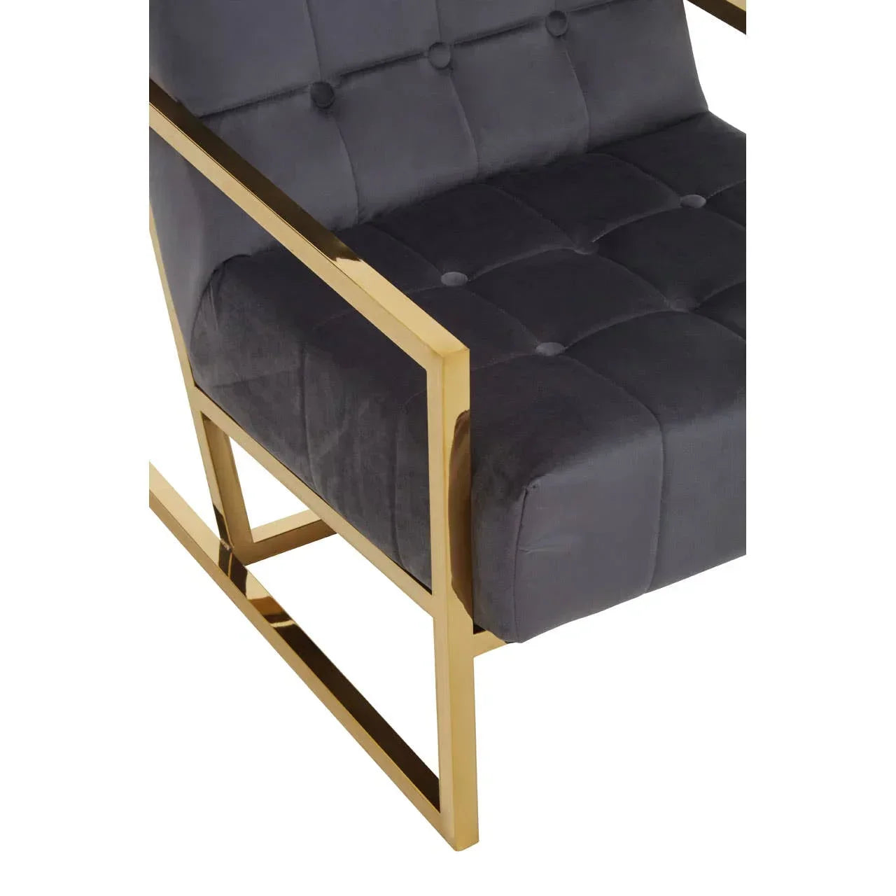 Grey velvet armchair with gold metal frame and tufted seat detail, angled side view