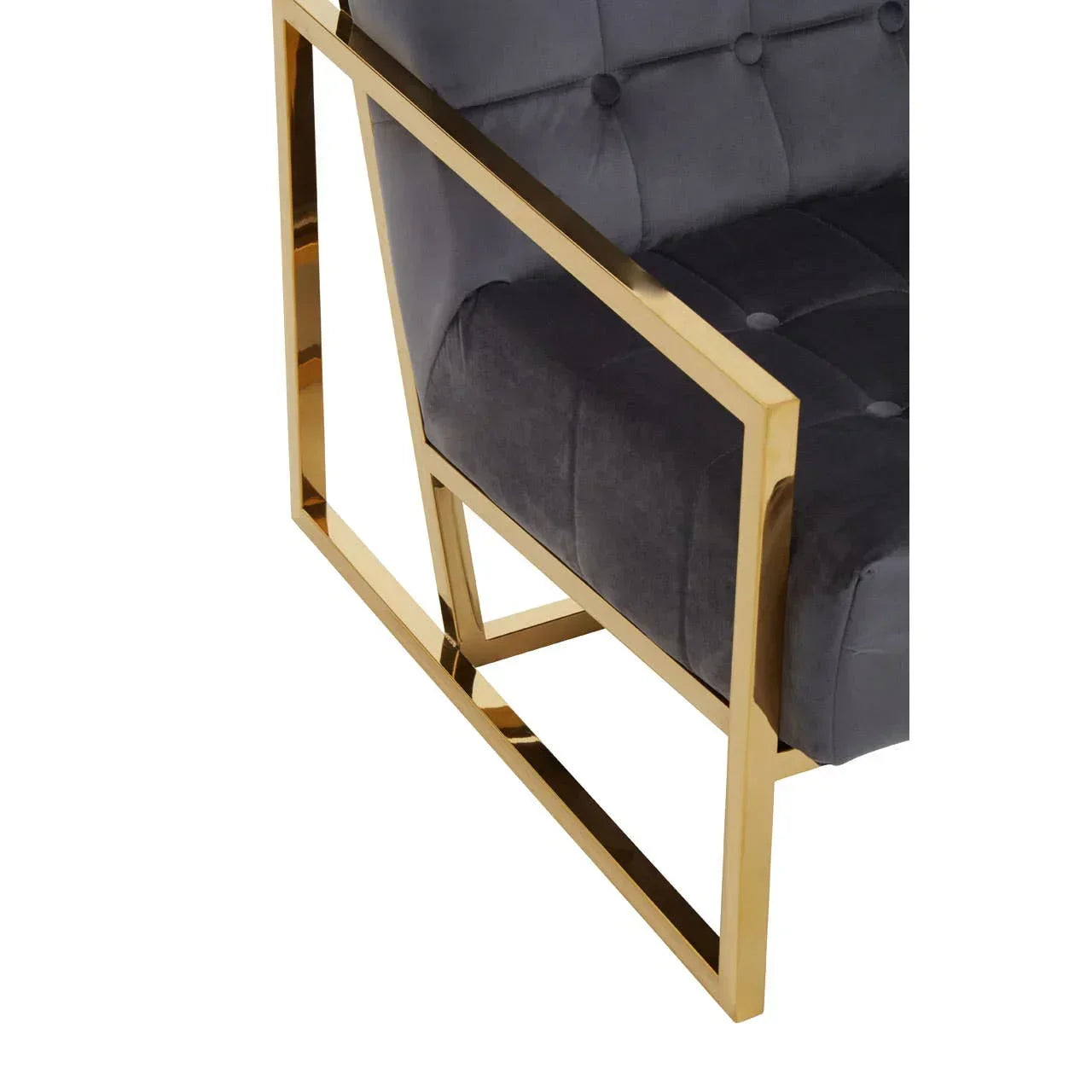 Grey velvet armchair with gold metal frame, close-up on tufted seat and geometric armrest
