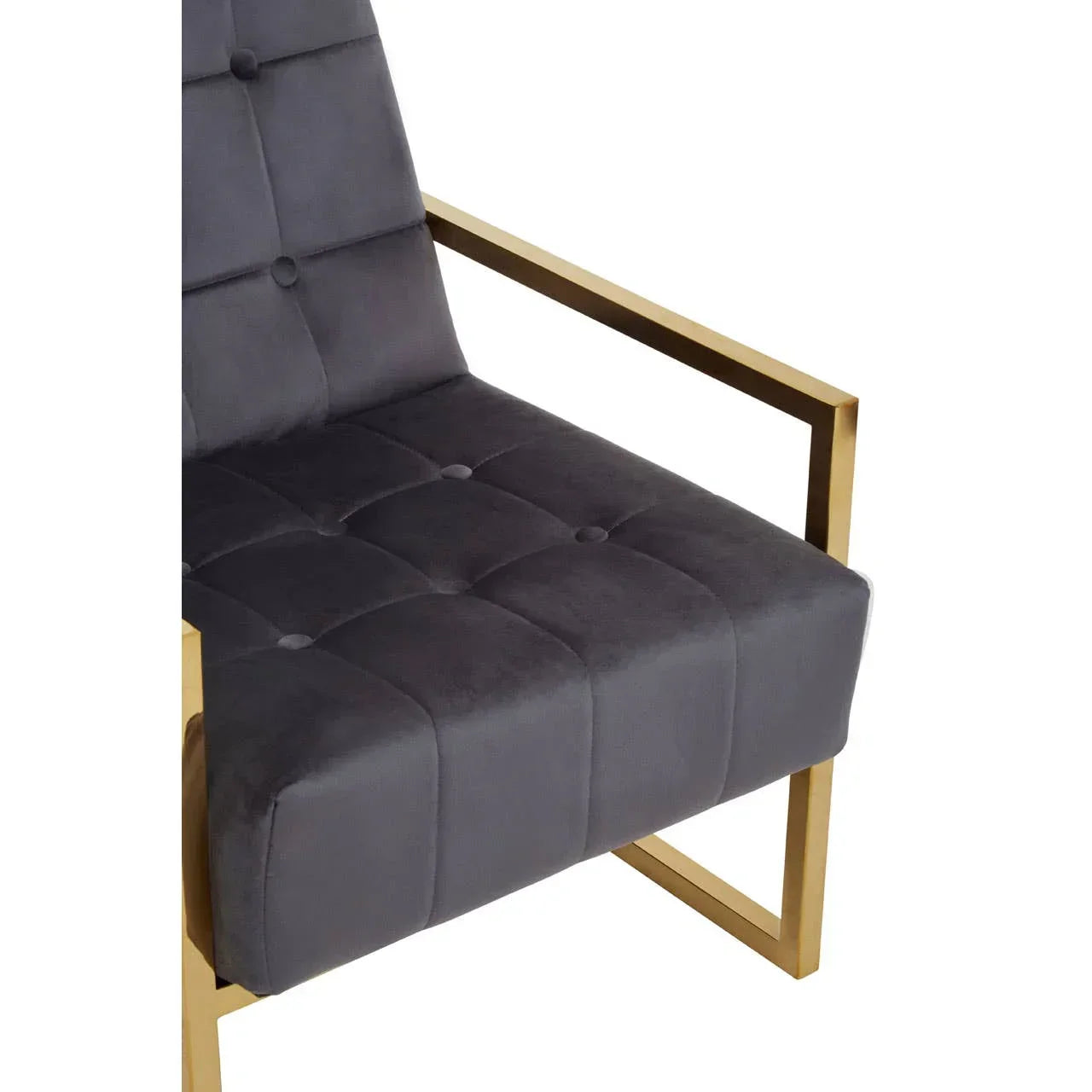 Grey velvet accent chair with gold metal frame and button-tufted seat close-up