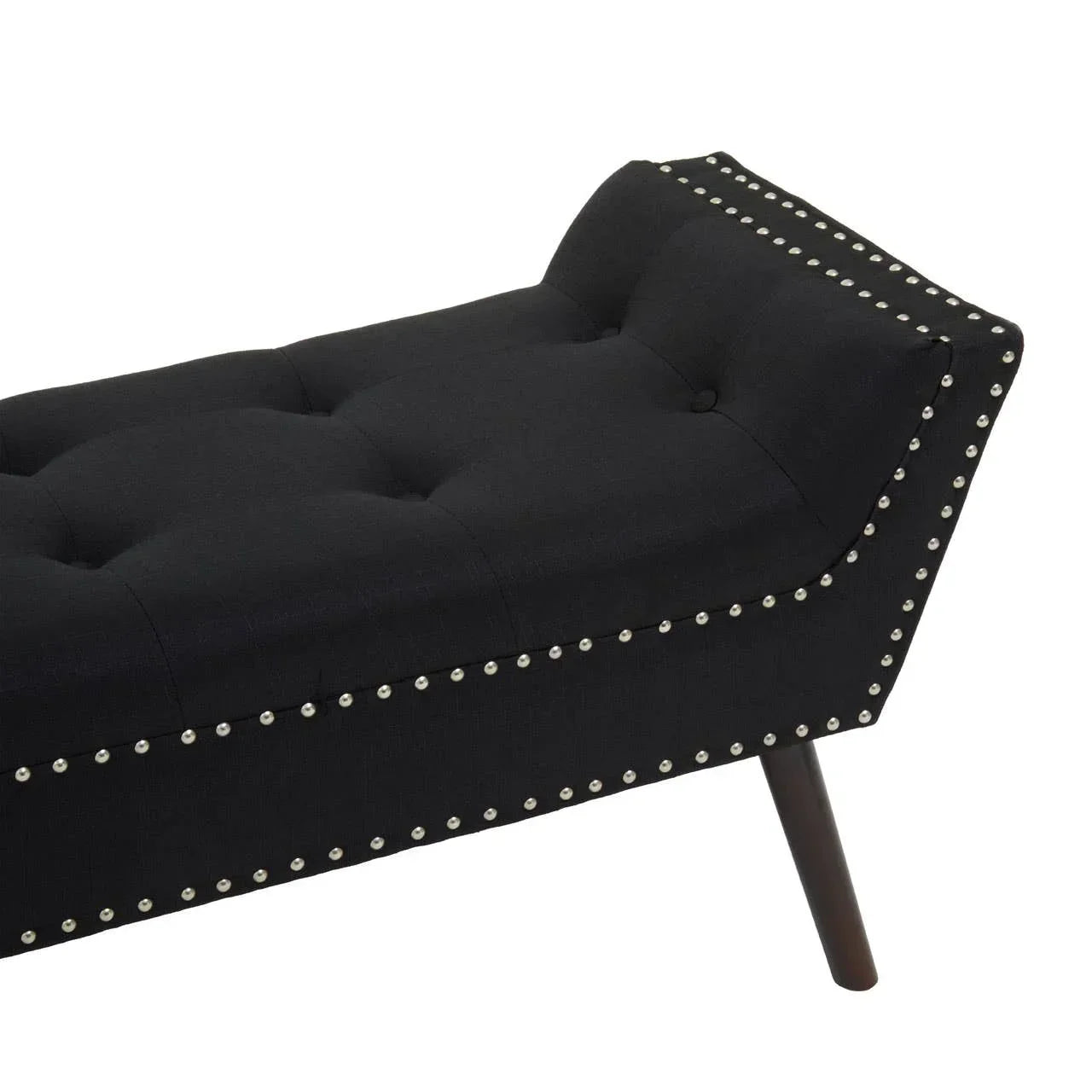 Black upholstered bench with button tufting and silver stud detailing on angled wood legs
