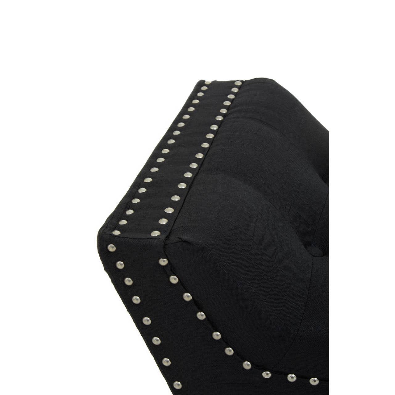 Black fabric sofa armrest with silver stud detailing and tufted upholstery close-up