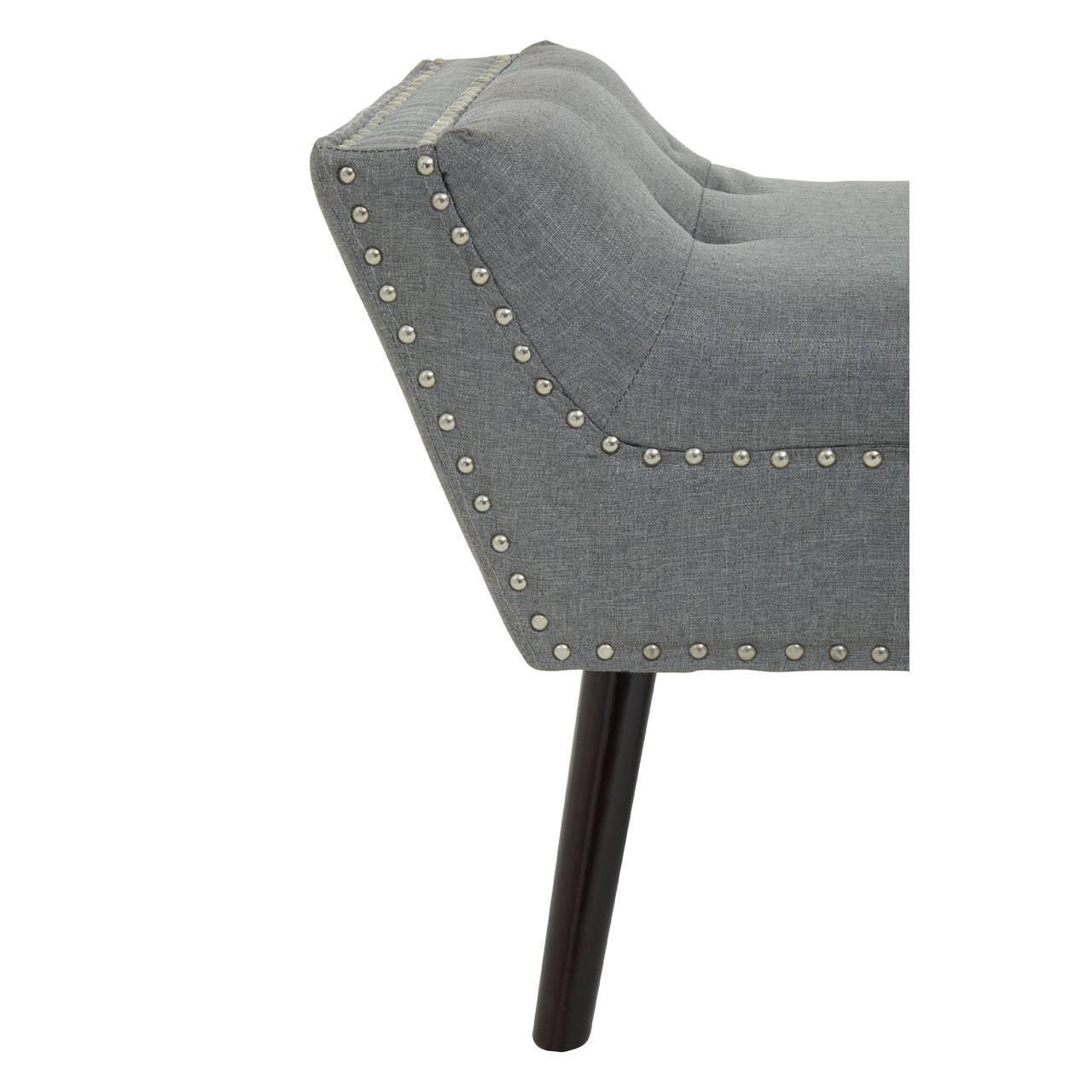 Grey upholstered bench with button detail and metal studs, dark wooden leg close-up