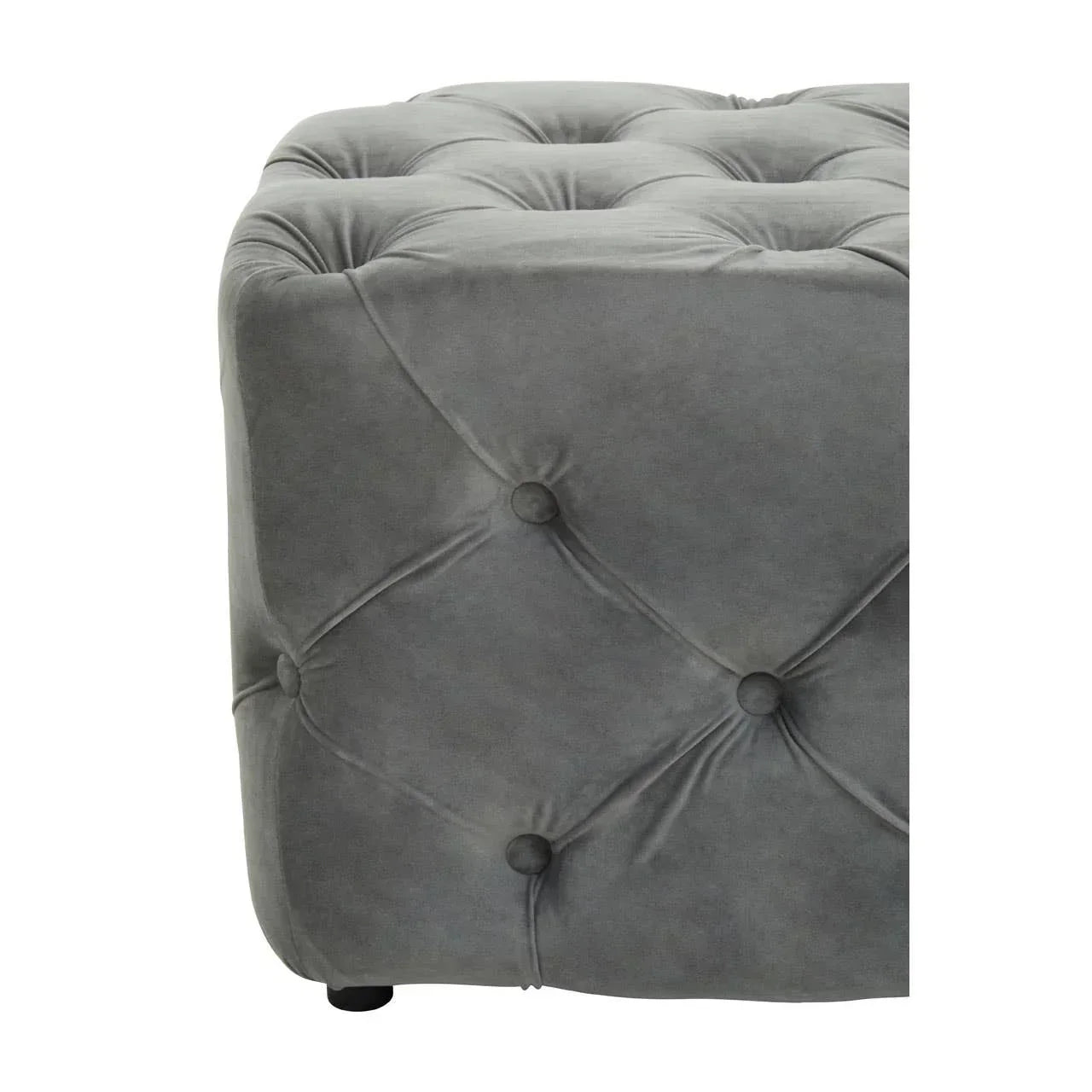 Grey velvet ottoman with button tufted upholstery, close corner view
