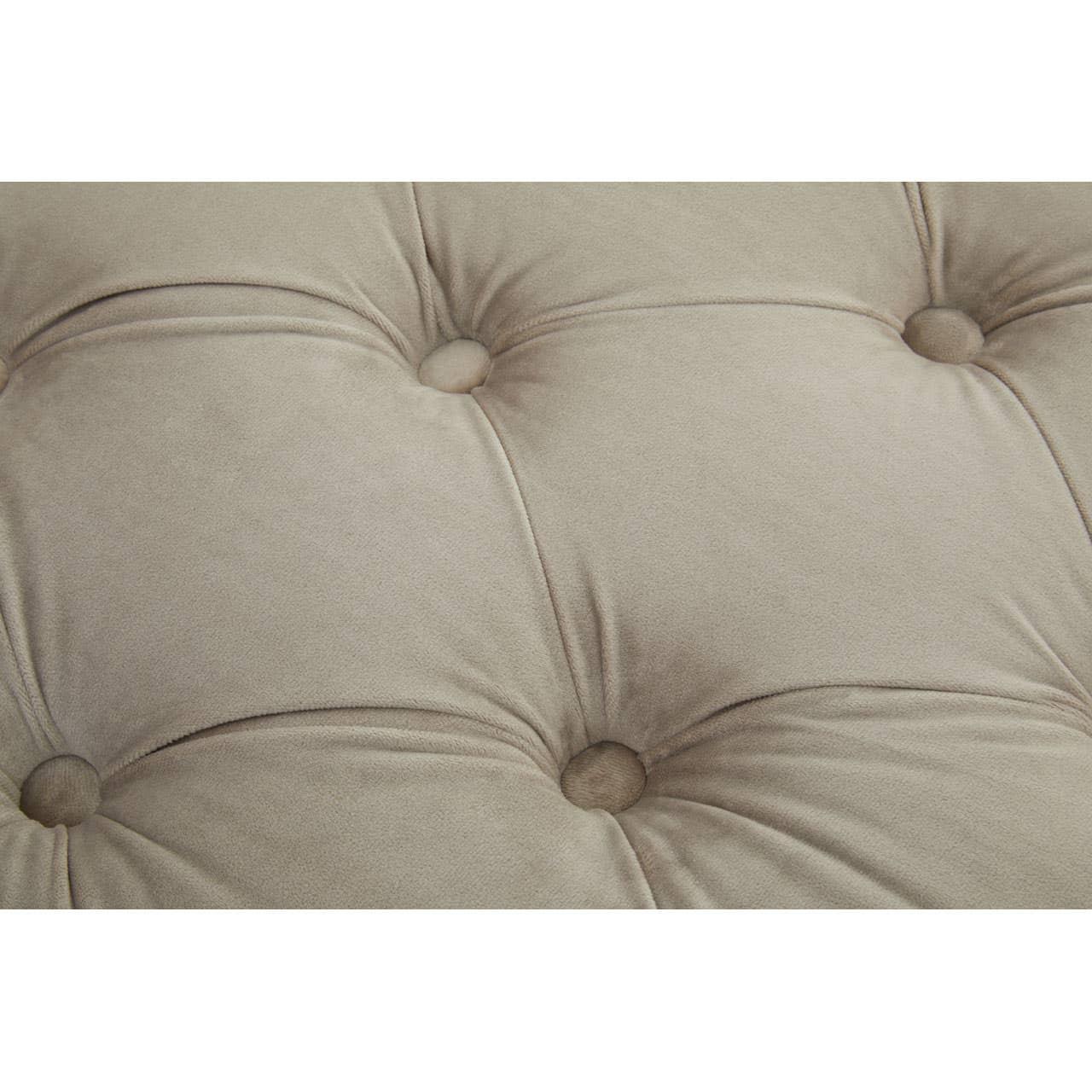 Beige fabric sofa cushion with deep button tufting detail, close-up view