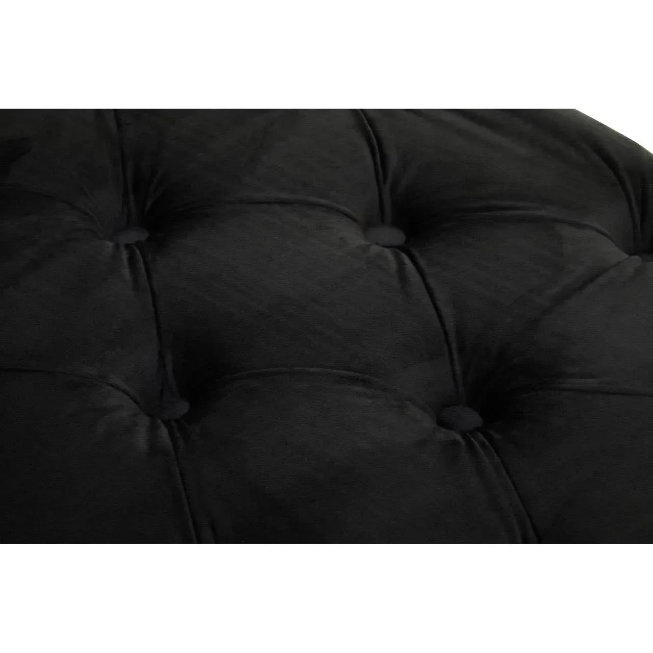 Black velvet sofa upholstery with deep button tufting close-up