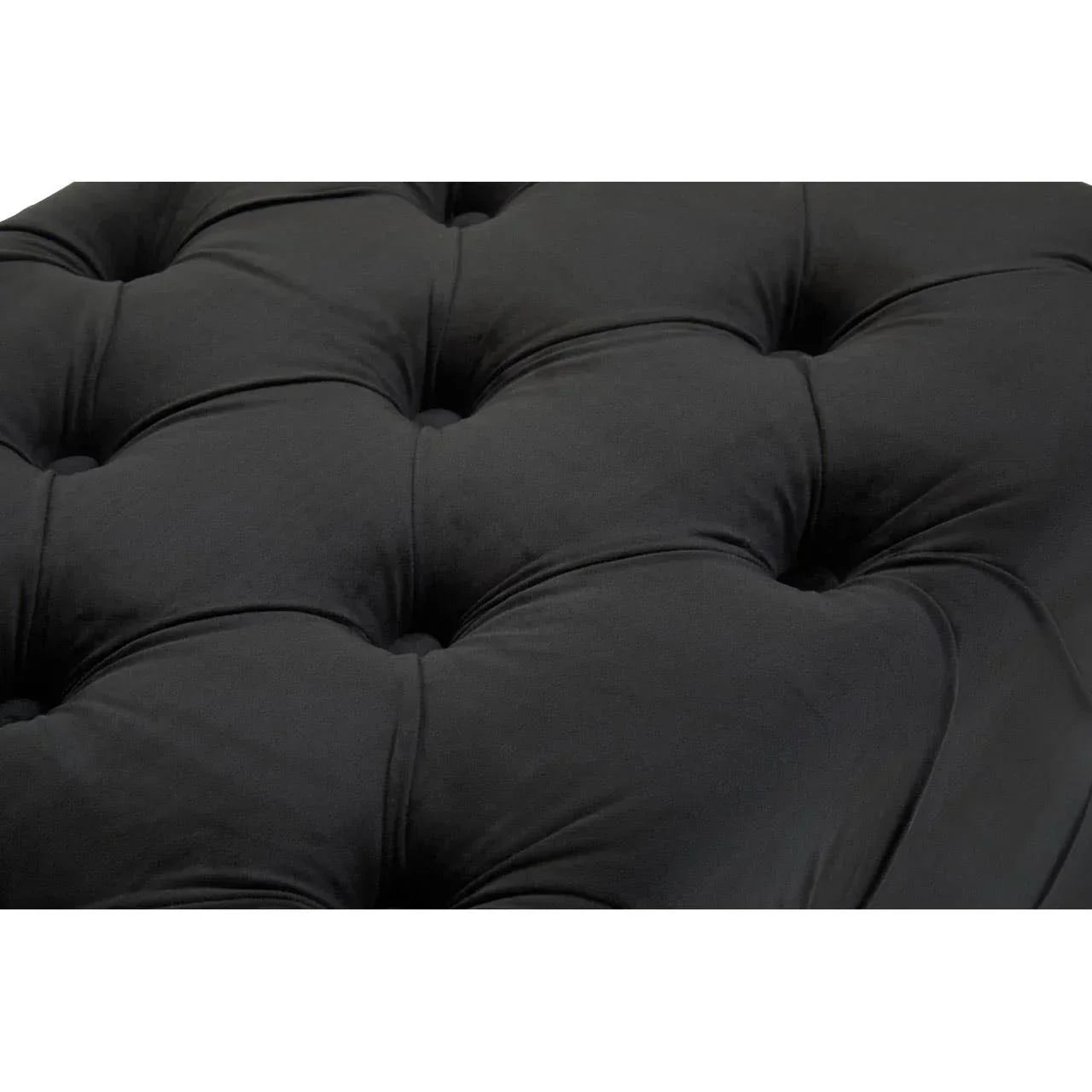 Black velvet sofa upholstery with deep button tufting, close-up of cushion texture