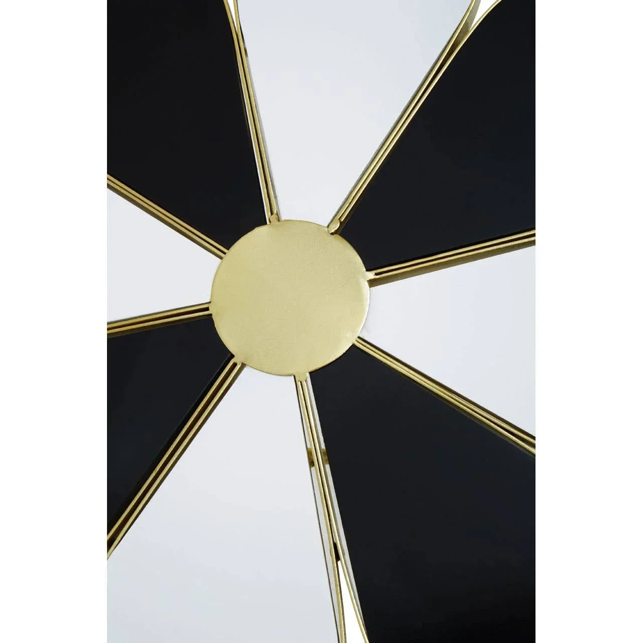 Close up of metal wall clock with black panels and gold spokes in modern design