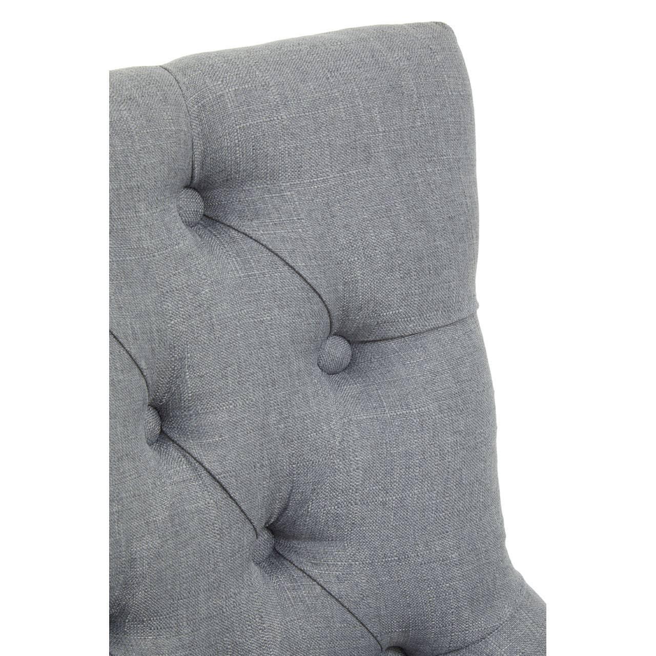 Closeup of grey fabric tufted chair backrest with button detailing
