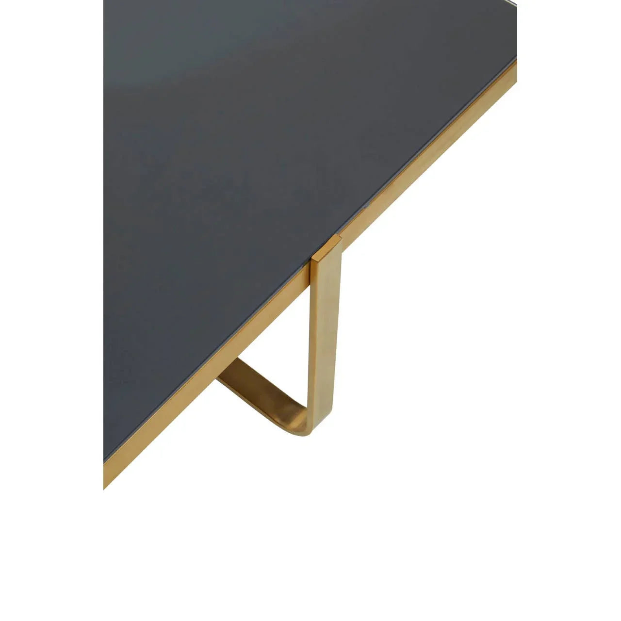 Glass top dining table with gold metal frame and leg detail, corner angle view