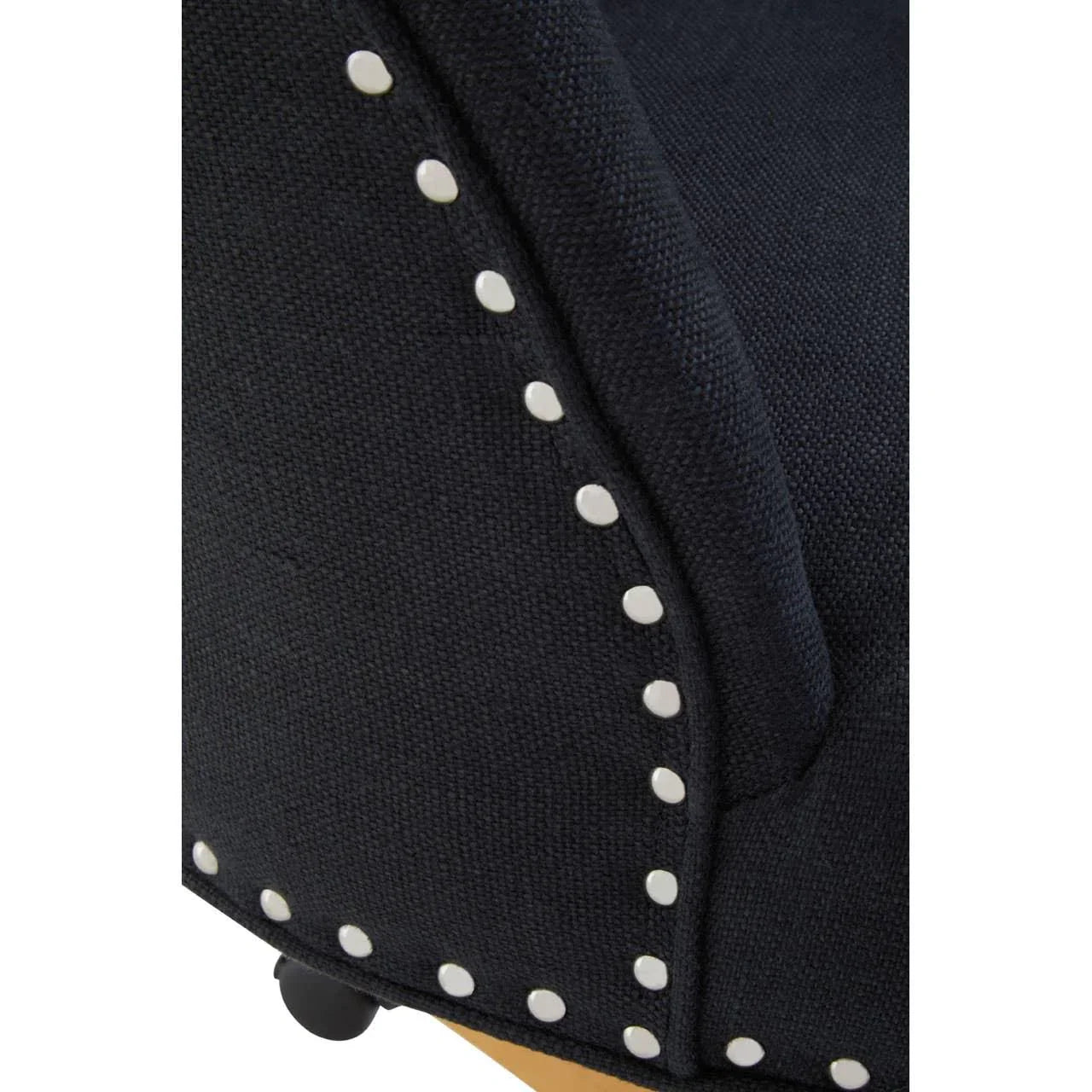 Closeup of black fabric armchair with silver studded trim and wooden leg base