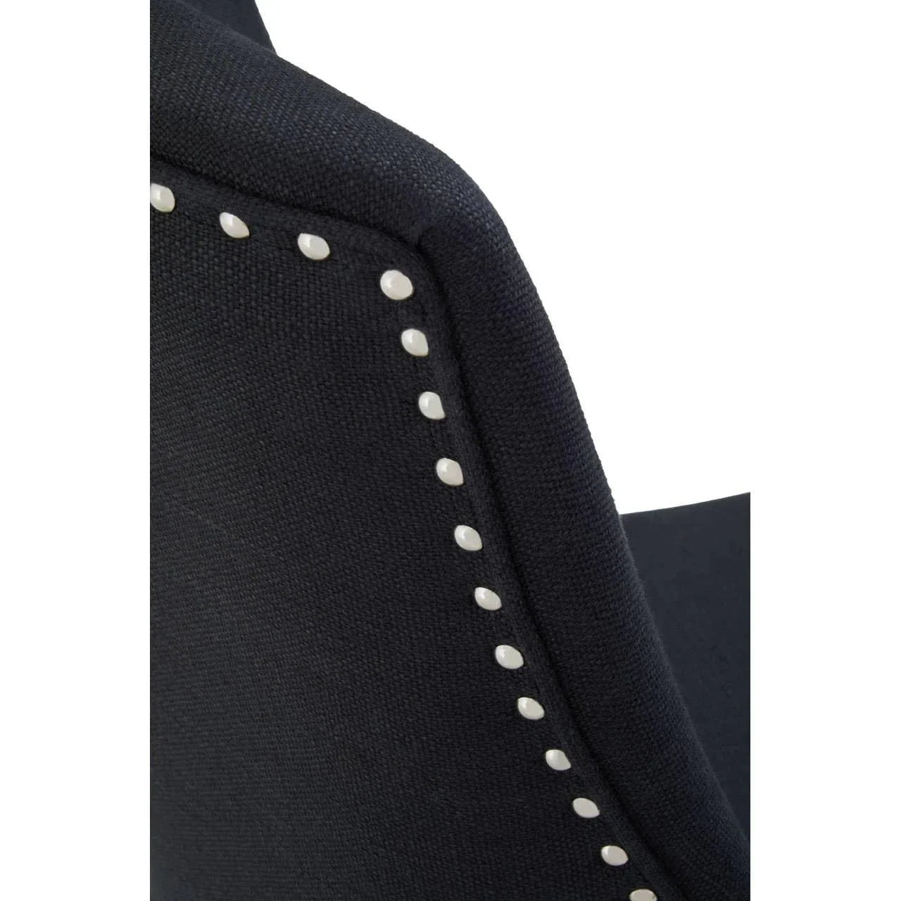 Close view of black fabric dining chair backrest with metal stud detail