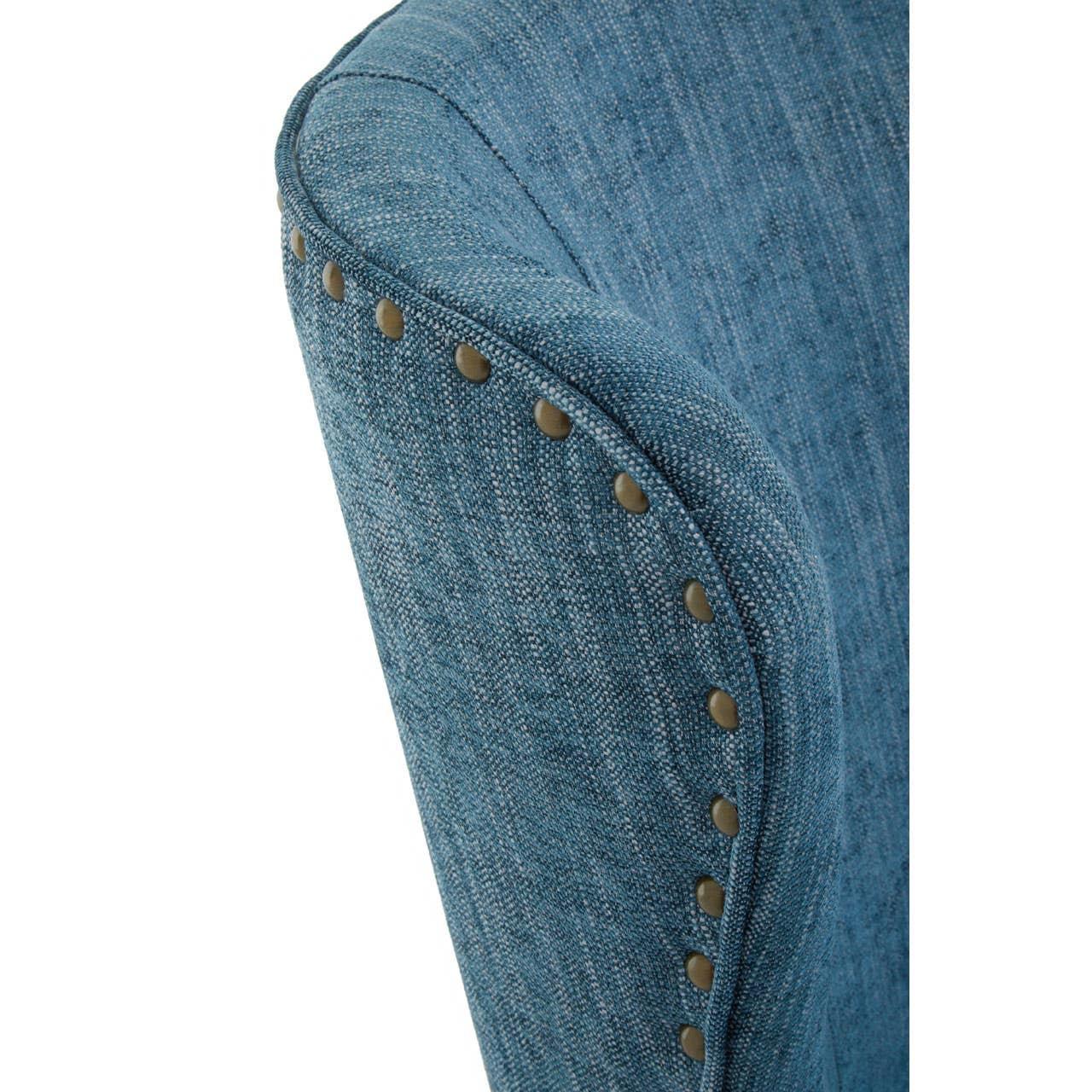 Blue fabric armchair with brass studded trim detail on curved backrest