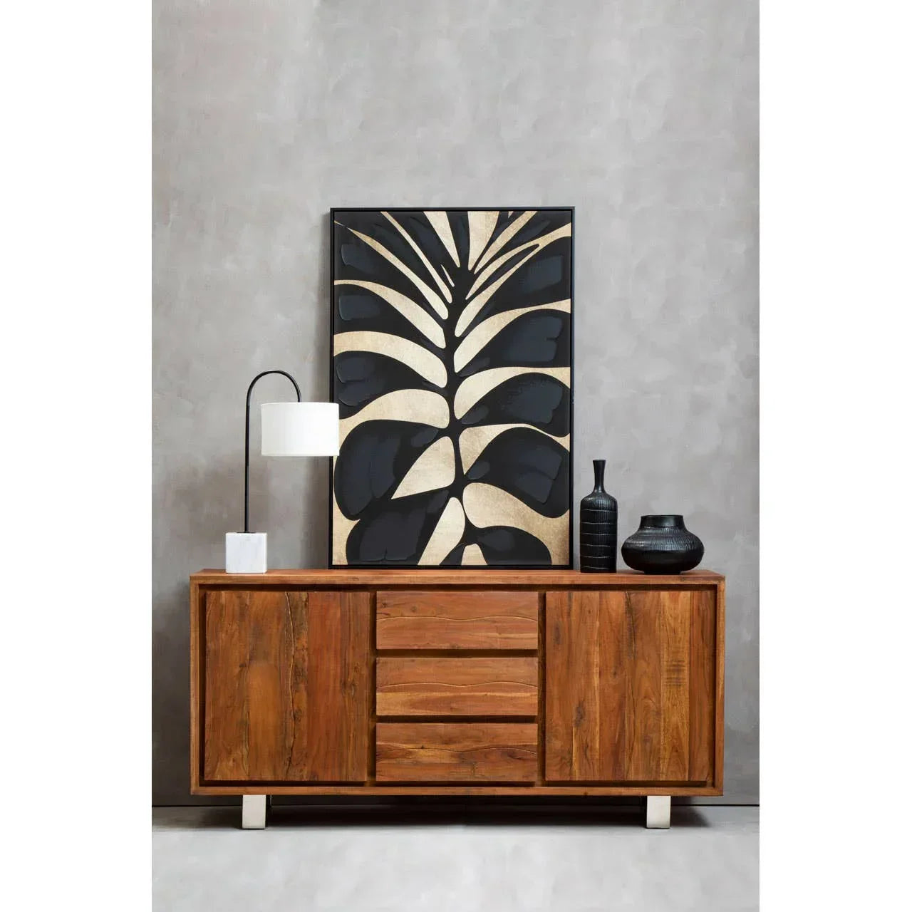 Solid wood sideboard with drawers, black vases, lamp, and modern leaf artwork display