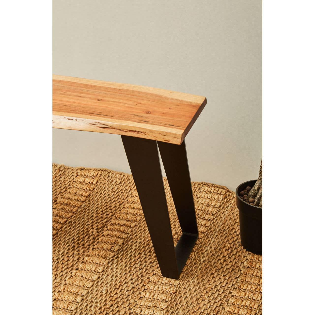 Wooden dining bench with black metal legs on woven rug
