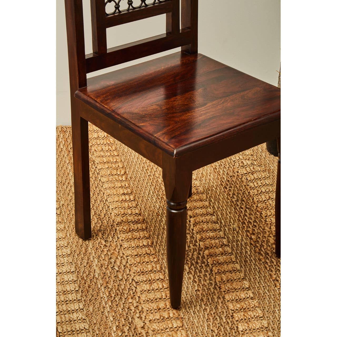 Dark wood dining chair with square seat and turned leg on woven jute rug