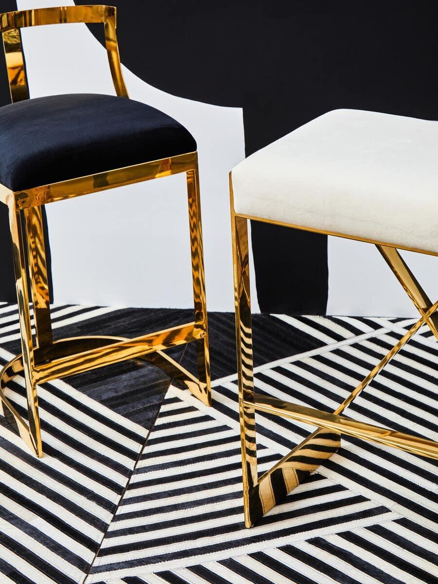 Gold metal frame dining chairs with black and white velvet seats on geometric rug