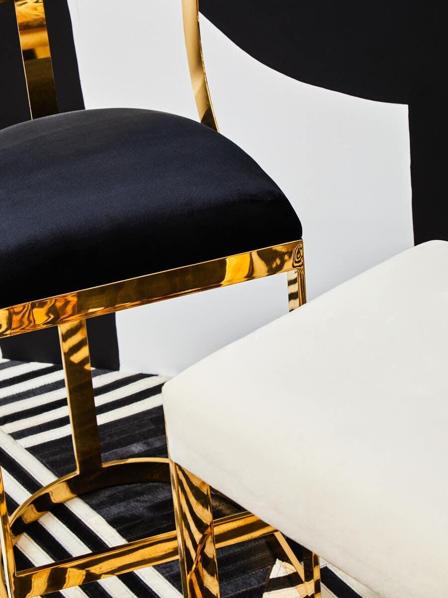Modern dining chairs with gold frames, one with black velvet seat, one with white upholstery