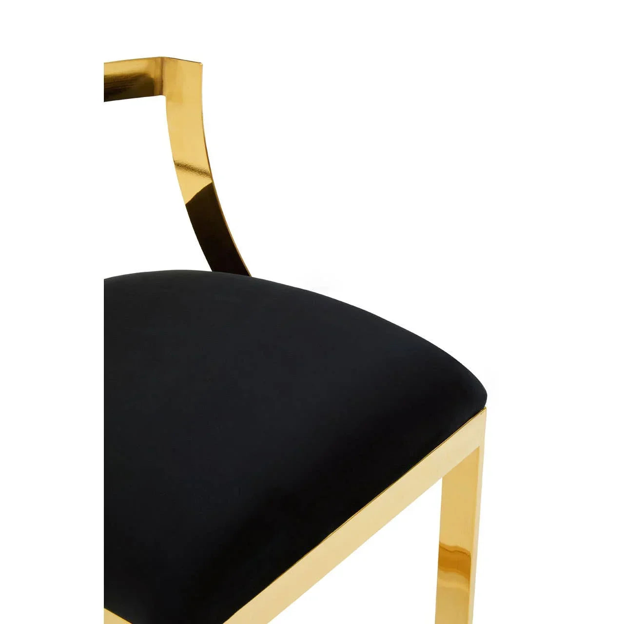 Black velvet dining chair seat with gold metal frame and partial backrest close-up