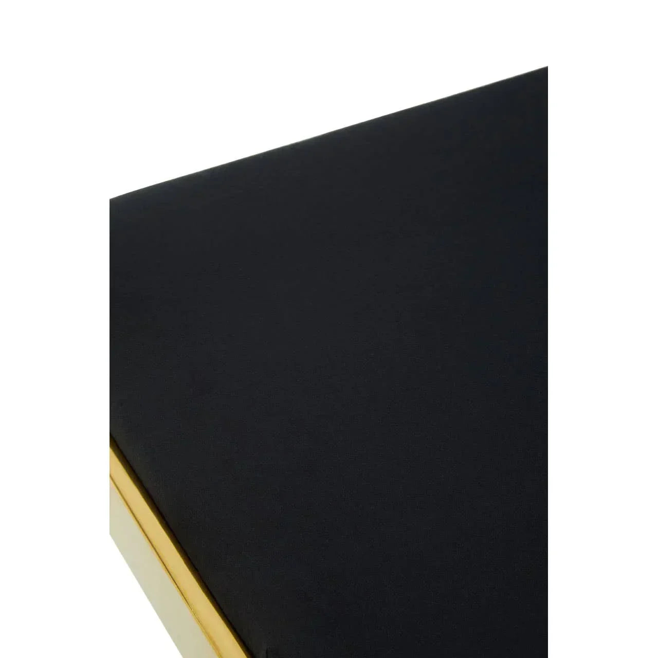 Closeup of black upholstered cushion with gold trim on furniture corner