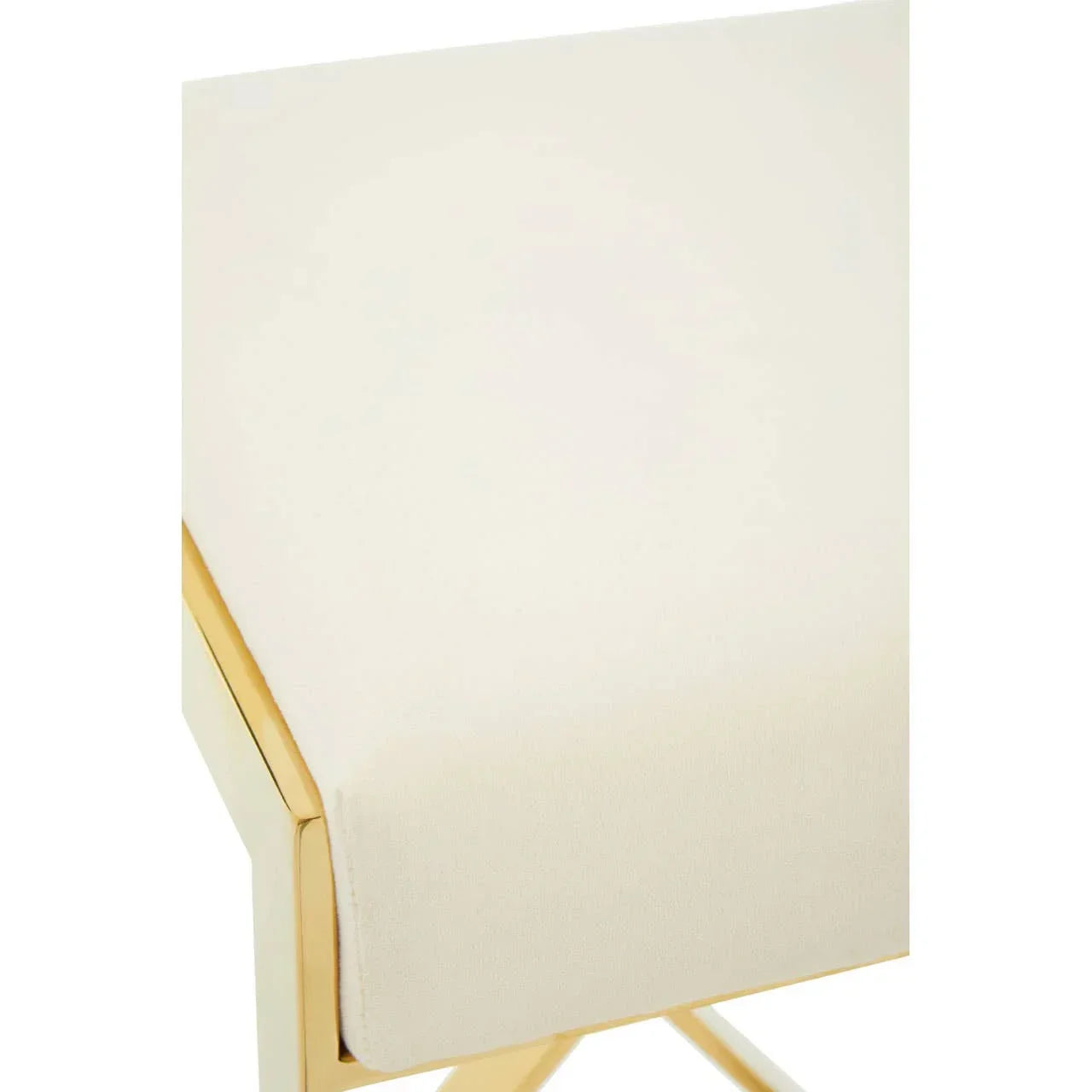 Cream upholstered dining chair seat with gold metal frame closeup