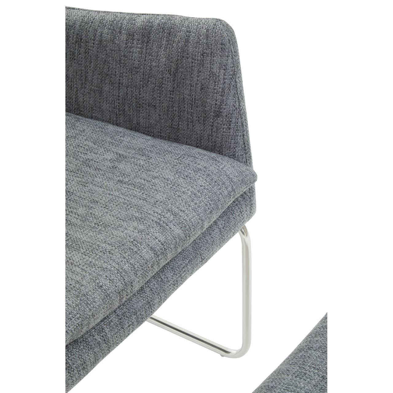 Closeup of grey fabric sofa seat with metal legs and curved upholstered backrest