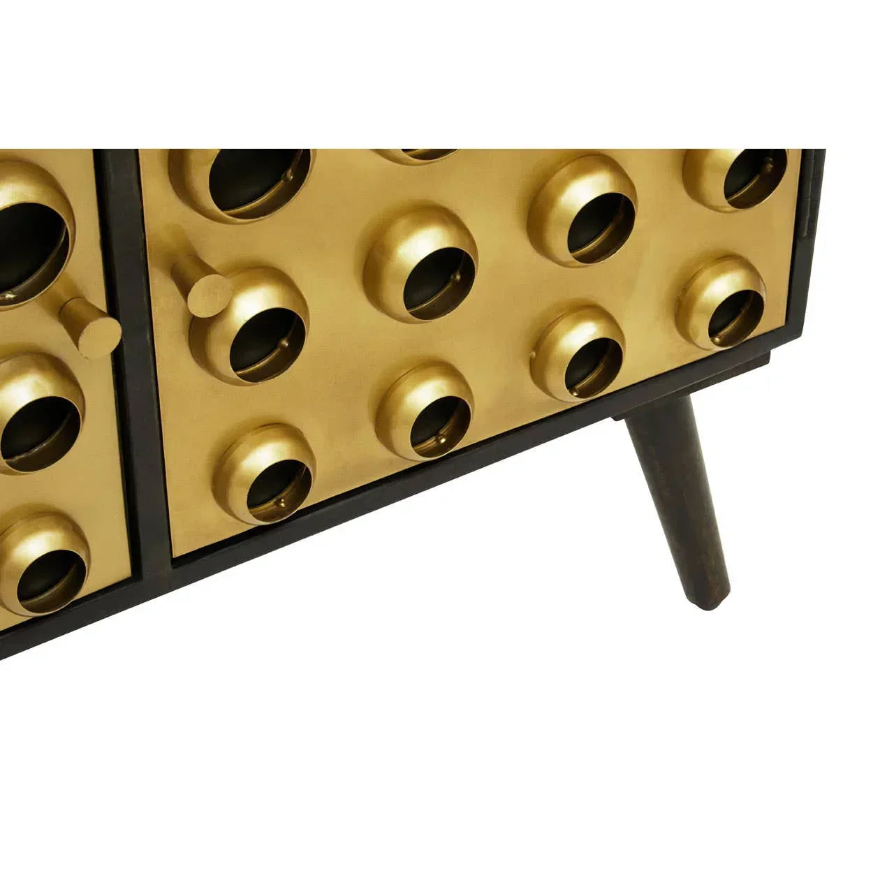 Close-up of gold accent sideboard with geometric drawer fronts and angled wooden leg