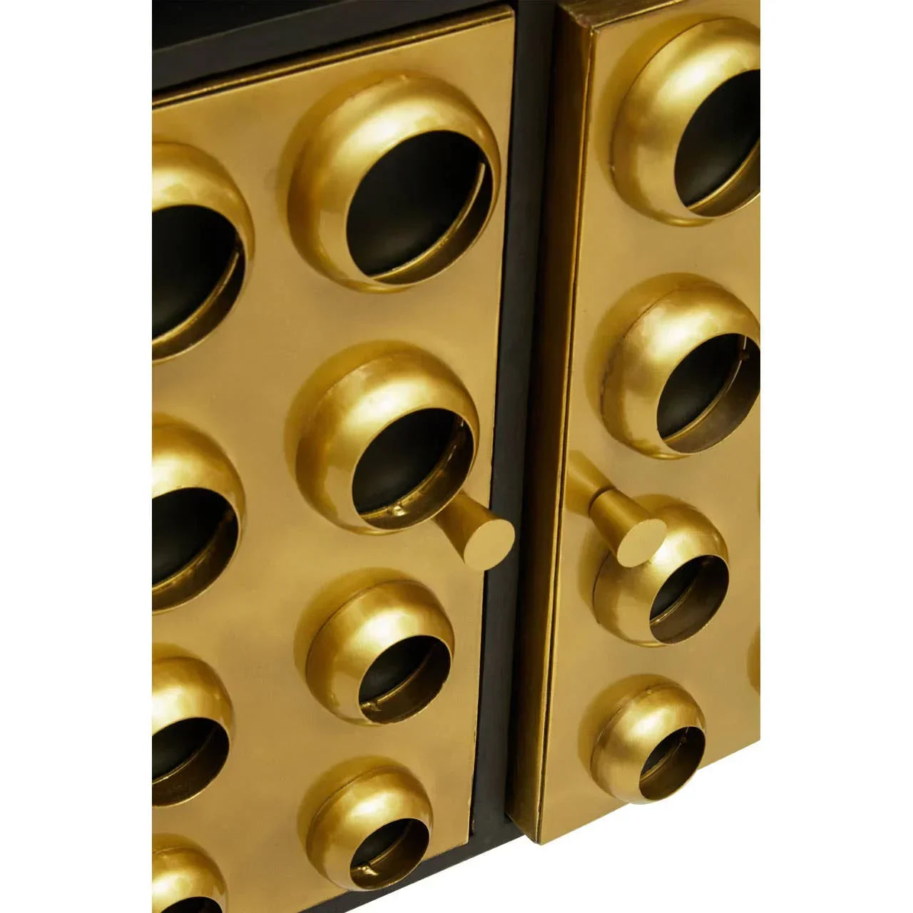 Gold cabinet doors with circular handles and geometric raised details, close-up view