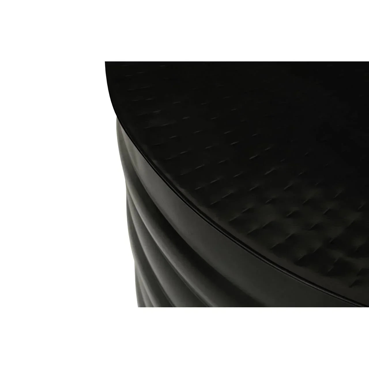 Black round side table with textured top and ribbed base, close-up of surface details