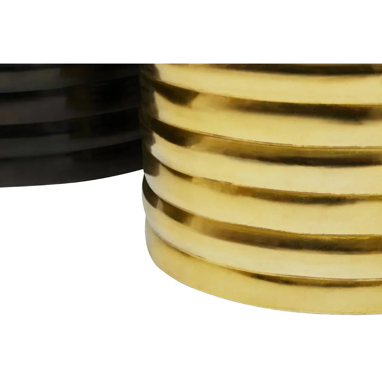Close-up of ribbed gold and black metal side table bases with reflective finish