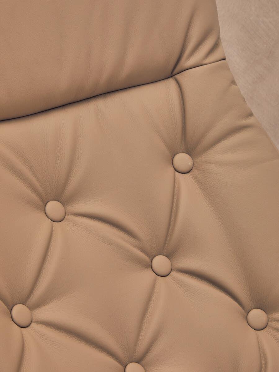 Close-up of tan leather sofa upholstery with button tufting detail