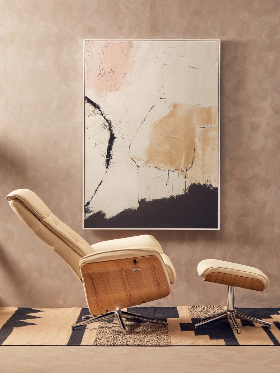 Beige recliner armchair and footstool with wood accents on patterned rug