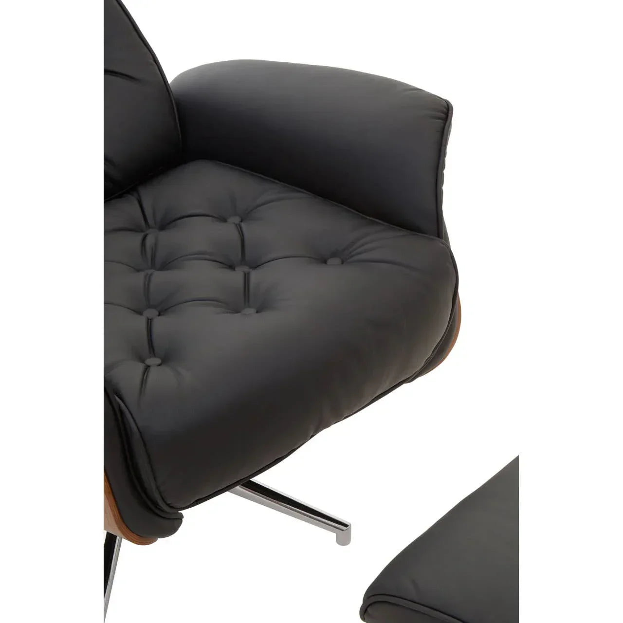 Close-up of black leather armchair with tufted seat and chrome legs