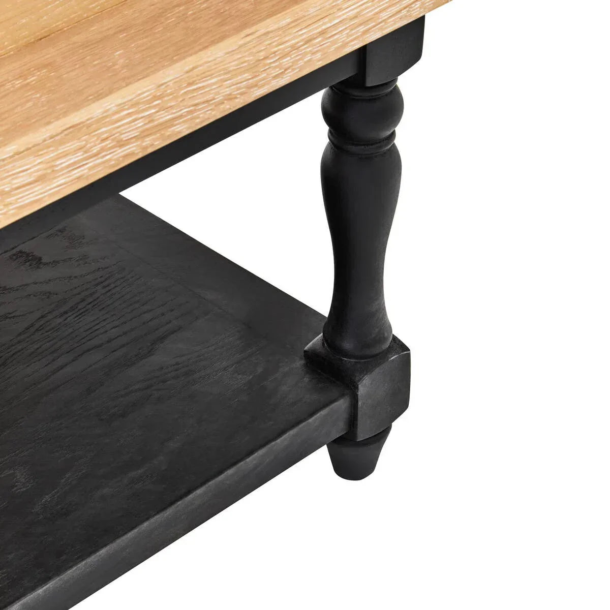 Wood coffee table with black turned leg and lower black shelf, close-up corner view