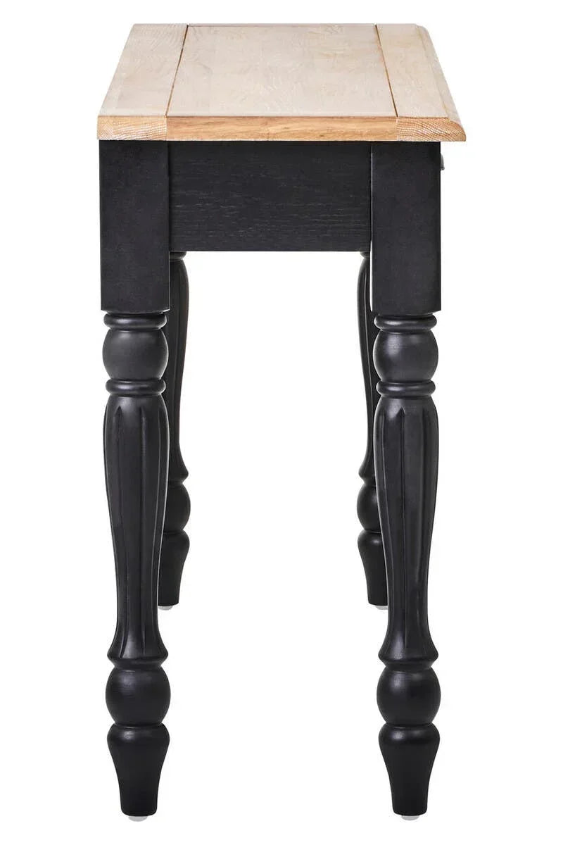 Wood dining table with black turned legs and light oak tabletop, side angle view