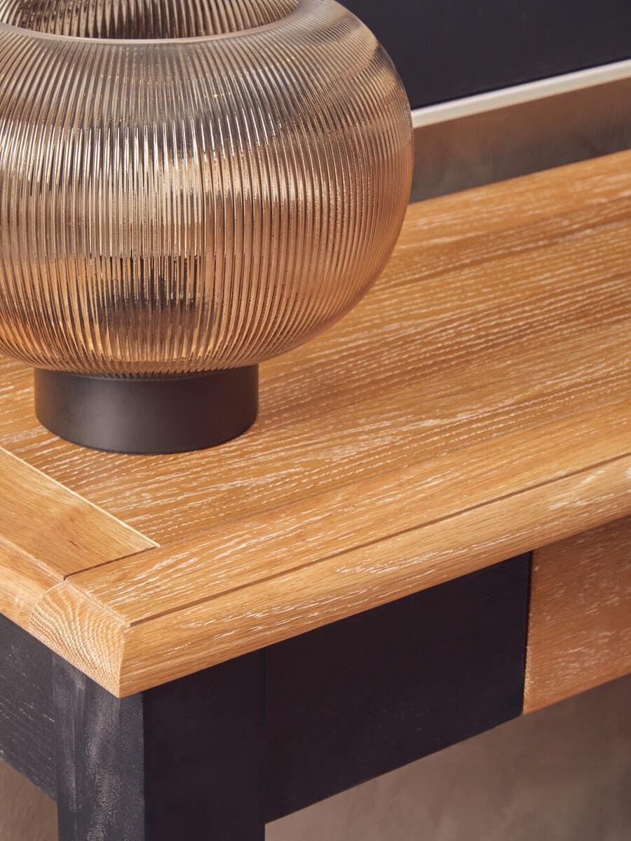 Oak console table with black legs and ribbed glass vase detail