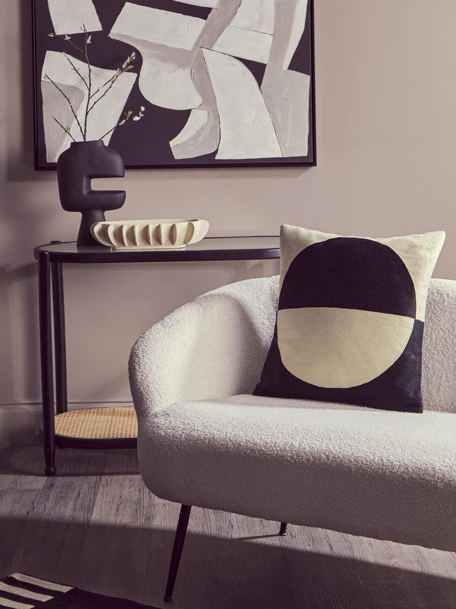 Modern boucle sofa with black and cream geometric cushion in a contemporary living room