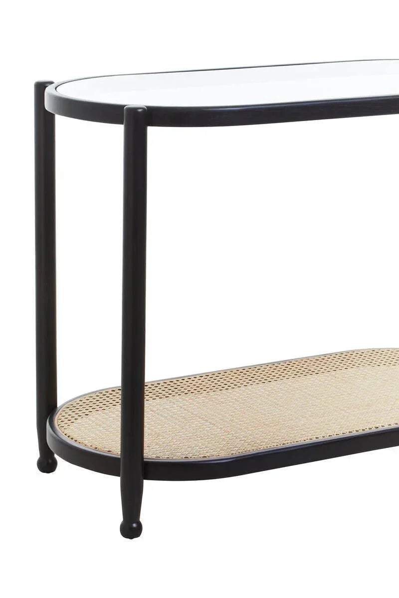 Black frame console table with glass top and woven rattan lower shelf, side angle view