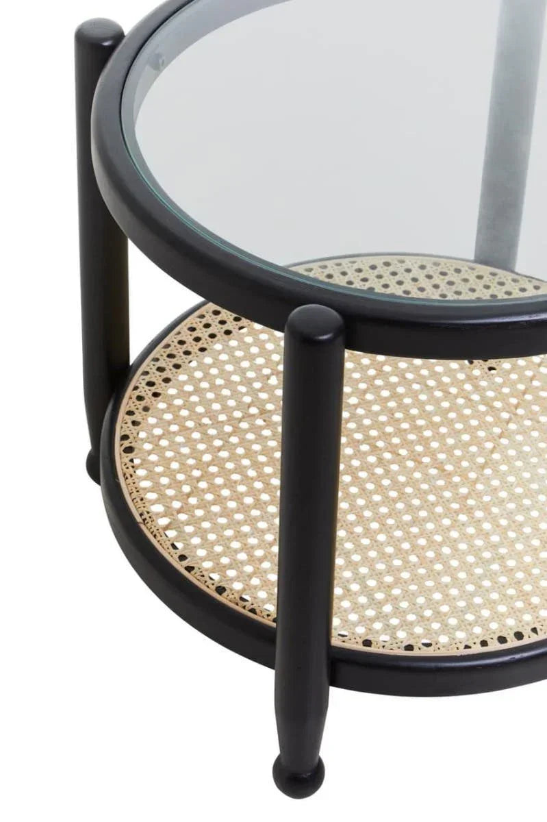 Round glass coffee table with black frame and cane shelf, close-up of tabletop and legs