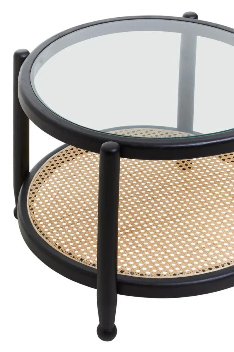 Round coffee table with black frame, glass top, and woven rattan shelf
