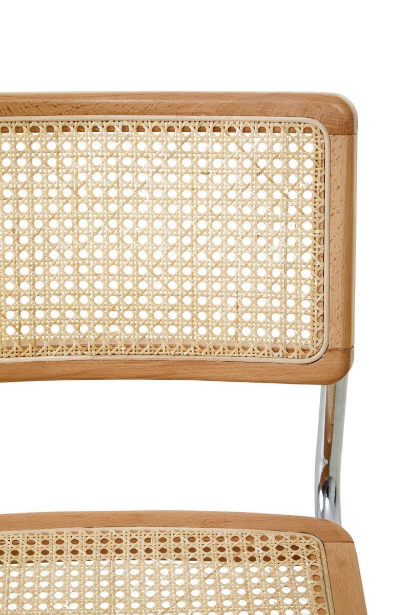 Closeup of rattan dining chair with natural wood frame and chrome metal support