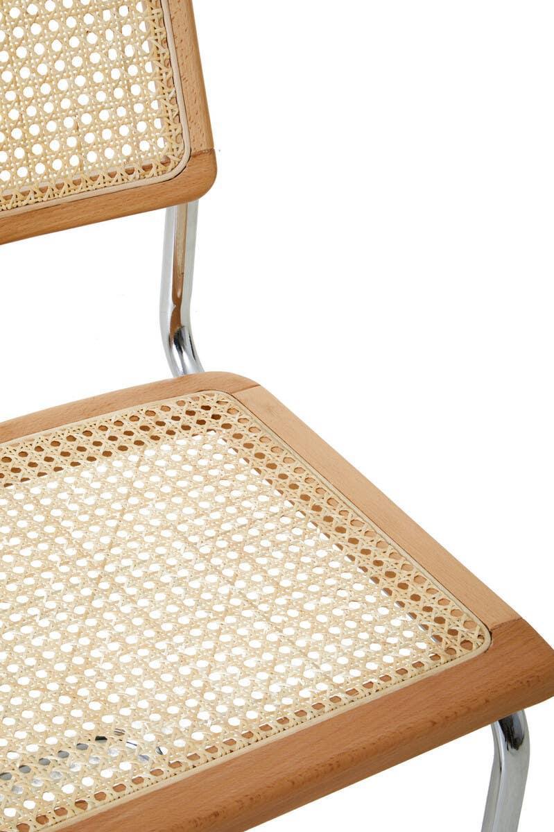 Close-up of cane dining chair with beech wood frame and chrome legs