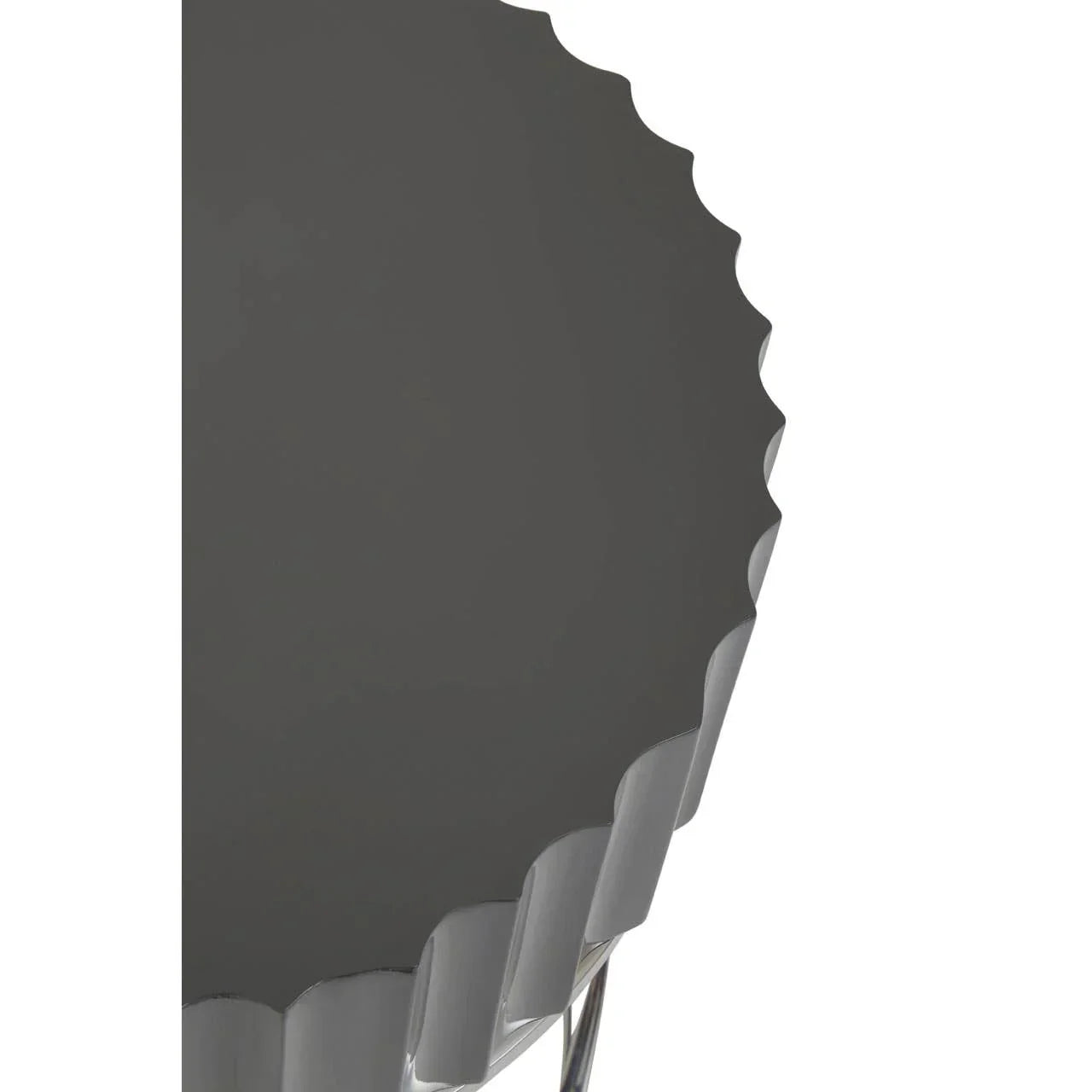 Close-up of black metal side table with scalloped edge and chrome legs
