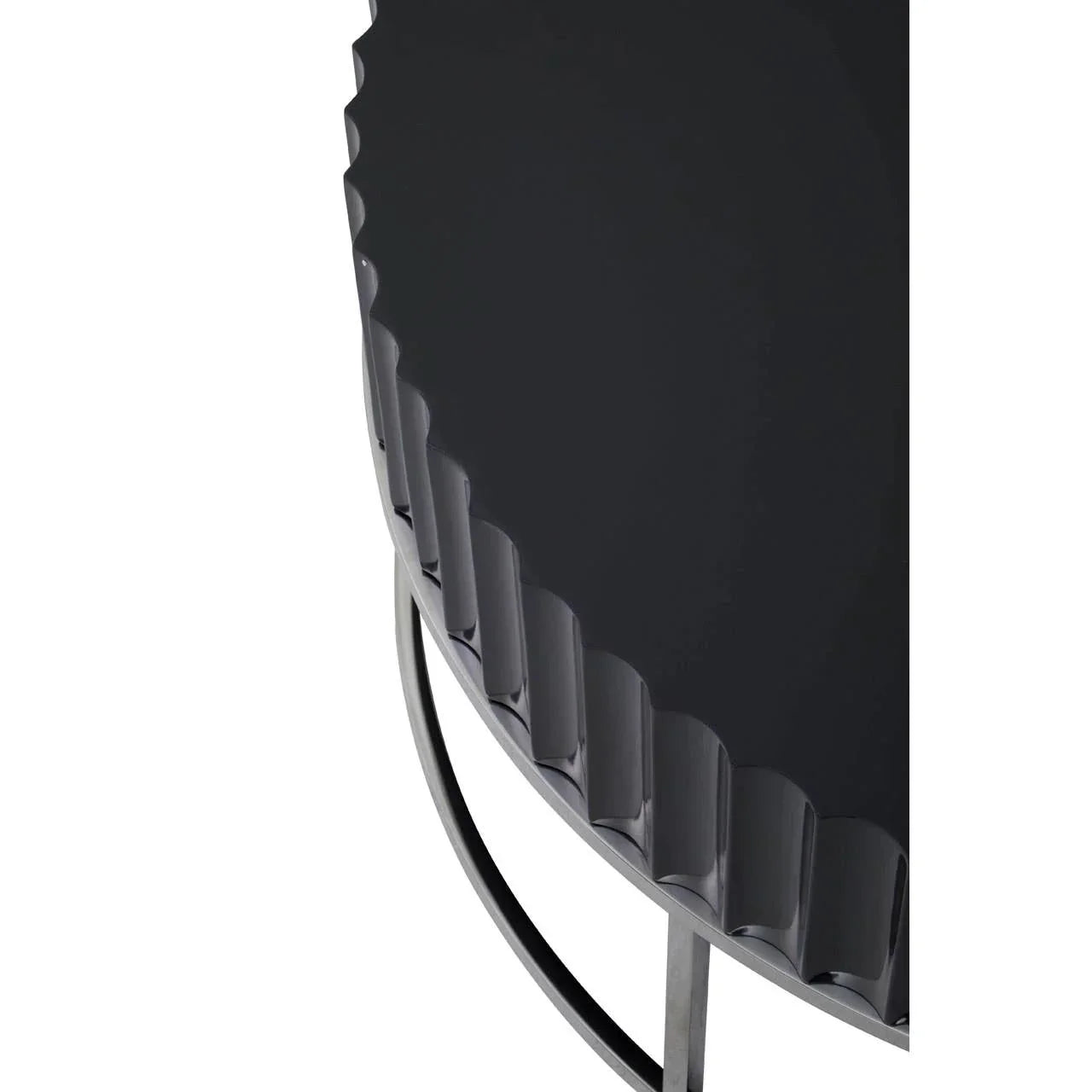 Black metal side table with scalloped edge and curved silver legs, close-up view