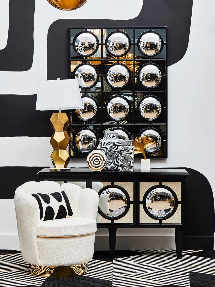 Modern mirrored sideboard with geometric accents, cream accent chair, gold table lamp