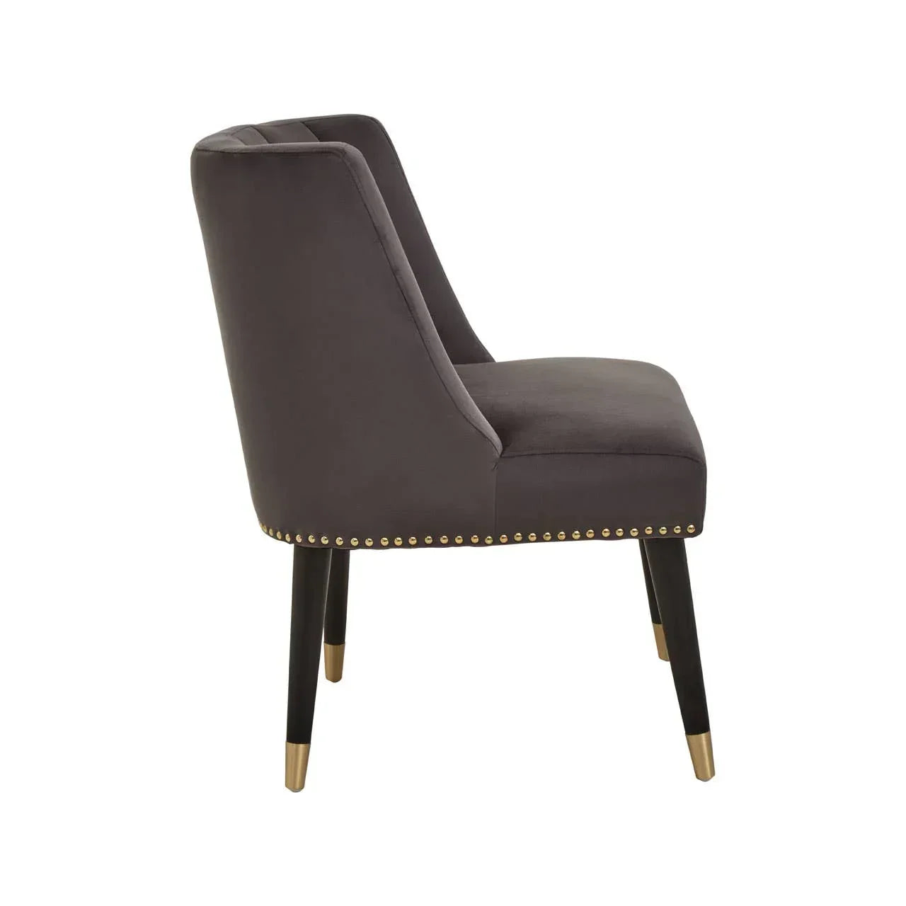 Grey velvet dining chair with gold stud trim and black legs, side view