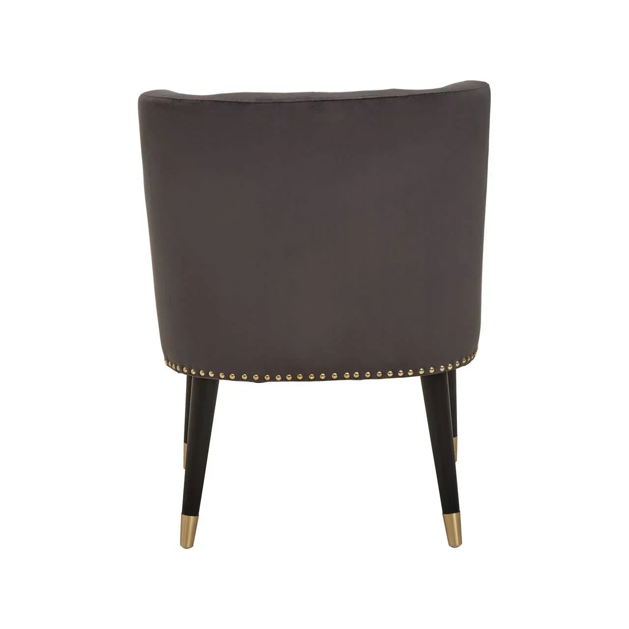 Rear view of grey upholstered accent chair with gold stud trim and black tapered legs