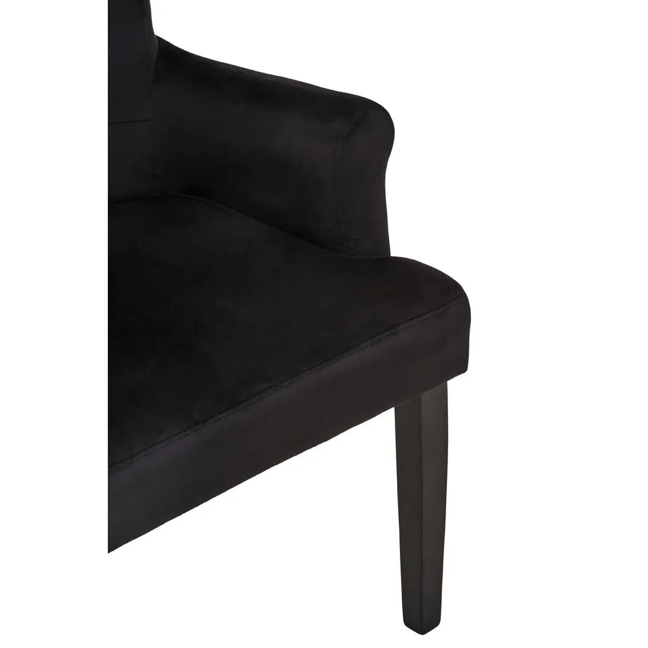 Black fabric armchair with curved armrest and wooden leg closeup