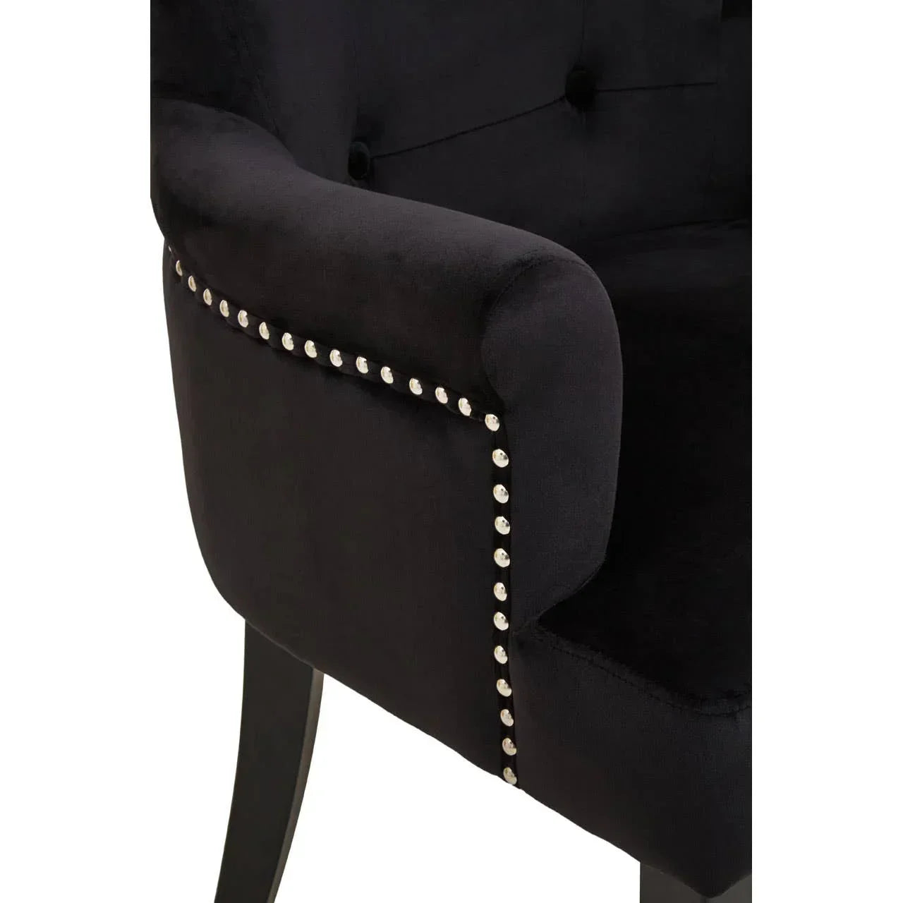 Black velvet armchair with silver stud detailing and tufted backrest close-up